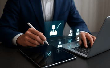 Business professional working with a tablet and laptop, using a digital stylus while reviewing holograms with selection icons and human profiles, representing digital HR processes.
